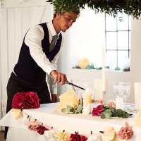 Vue verticale d’une bougie crème de 150 mm allumée sur une table décorée.