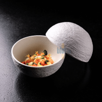 Sphère blanche INSITU servant une entrée gastronomique – Présentation raffinée en salle