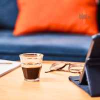 Petit verre à café Duralex Picardie de 9 cl posé sur une table, ambiance chaleureuse avec canapé en arrière-plan.