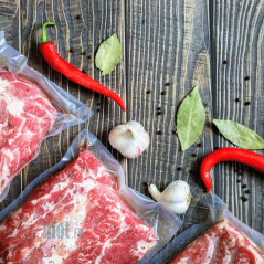 Sachets alimentaires sous vide avec morceaux de viande épicés et aromates