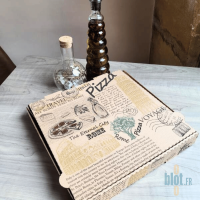 Boîte à pizza kraft brun ROMA 29x29x3,8 cm posée sur une table avec bouteilles d’huile.