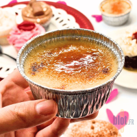 Crème brûlée servie dans un godet aluminium jetable tenue en main
