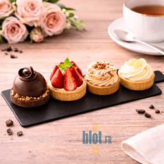 Mini pâtisseries assorties disposées sur support rectangle noir à languette