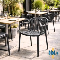 fauteuils SERENA anthracite installés sur une terrasse de restaurant dans une ambiance contemporaine et végétalisée