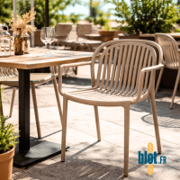 Fauteuil SERENA taupe installé en terrasse de restaurant avec table extérieure