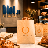 Sac viennoiserie kraft brun imprimé Tu me fais croquer présenté en boulangerie avec croissant