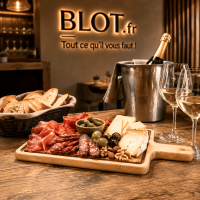 Plateau avec poignée De La Roca garni de charcuteries, fromages, olives et fruits secs sur une table de restaurant