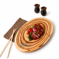 Planche ovale De La Roca en bouleau avec thon dressé, condiments et baguettes