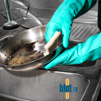 Éponge grattante Sponrex 100 utilisée pour récurer une poêle en cuisine professionnelle