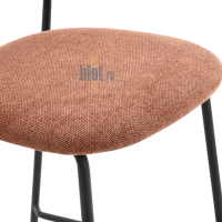 Gros plan sur l’assise rembourrée en tissu terracotta du tabouret AGATE